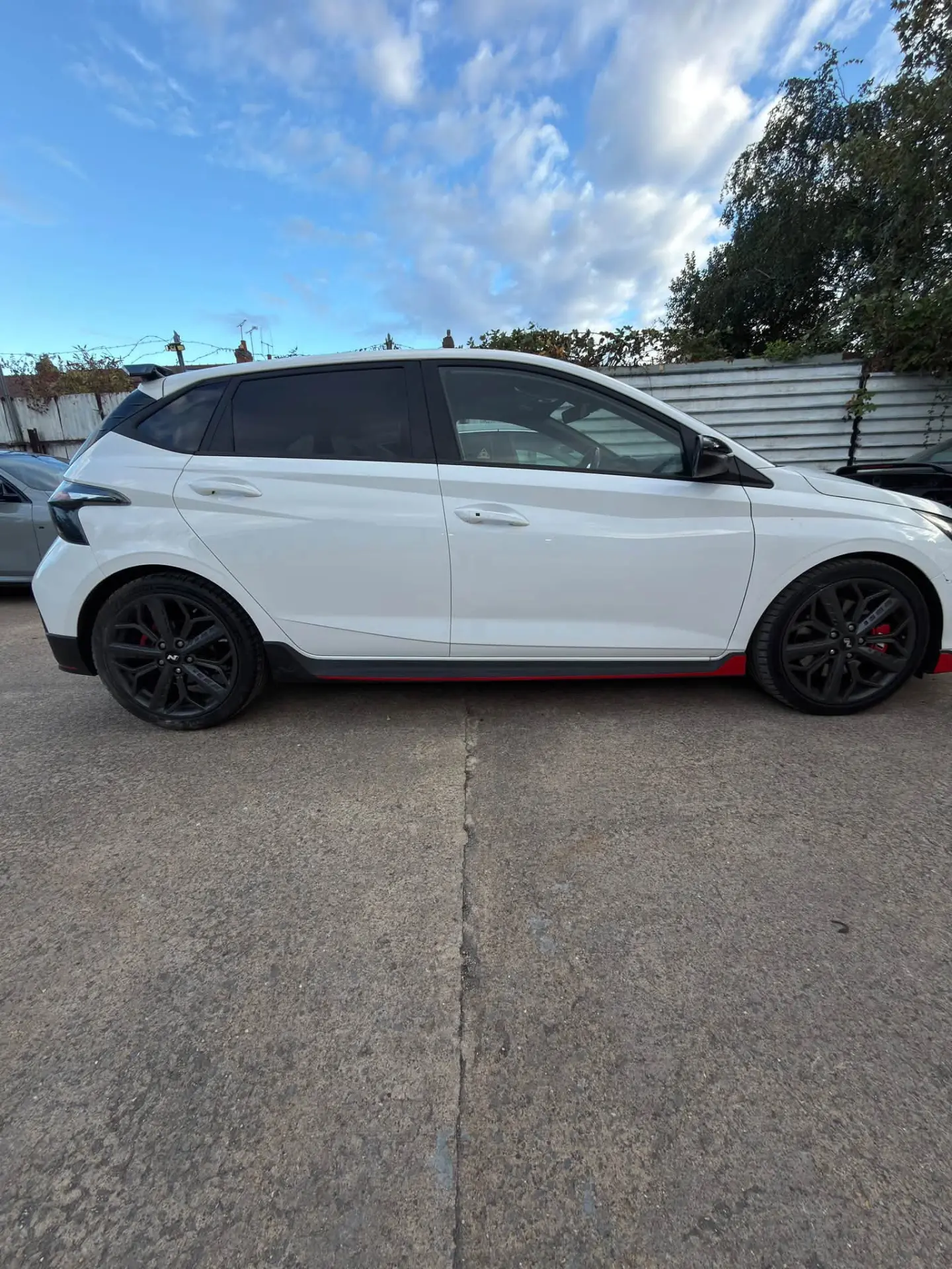 White Hyundai i20 N front three-quarter view in the workshop yard